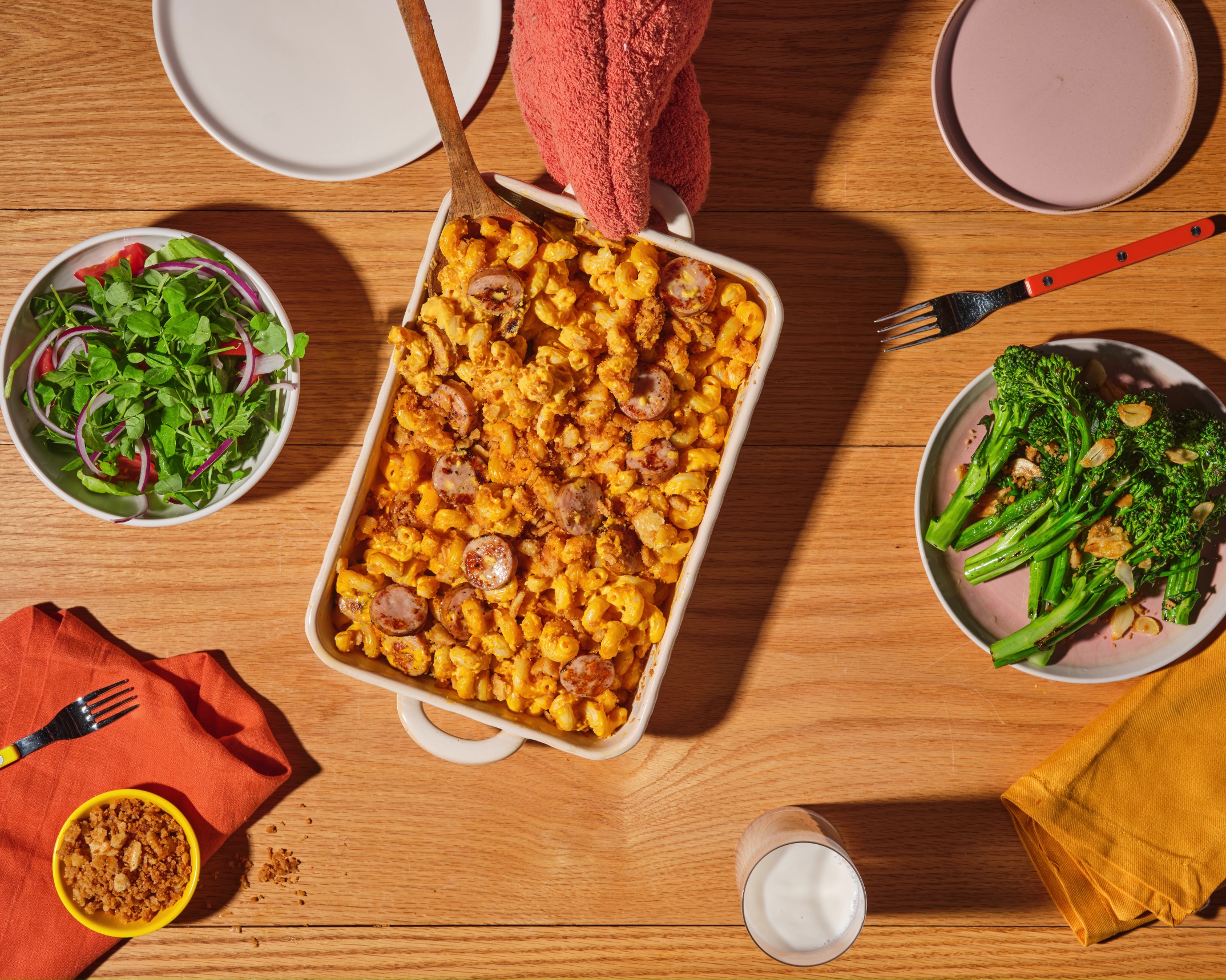 Baked mac and cheese with The Sausage Project Melty Cheddar Chicken Sausage coins and buttery cracker topping in a casserole dish.