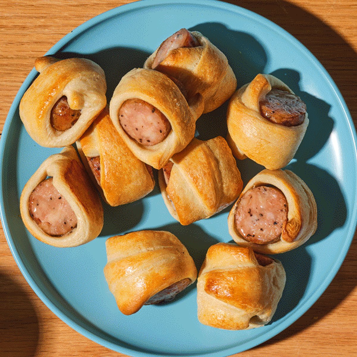 Bite-size crescent-wrapped chicken sausages served with maple-Dijon dipping sauce on a platter and called Chicks in a Quilt.