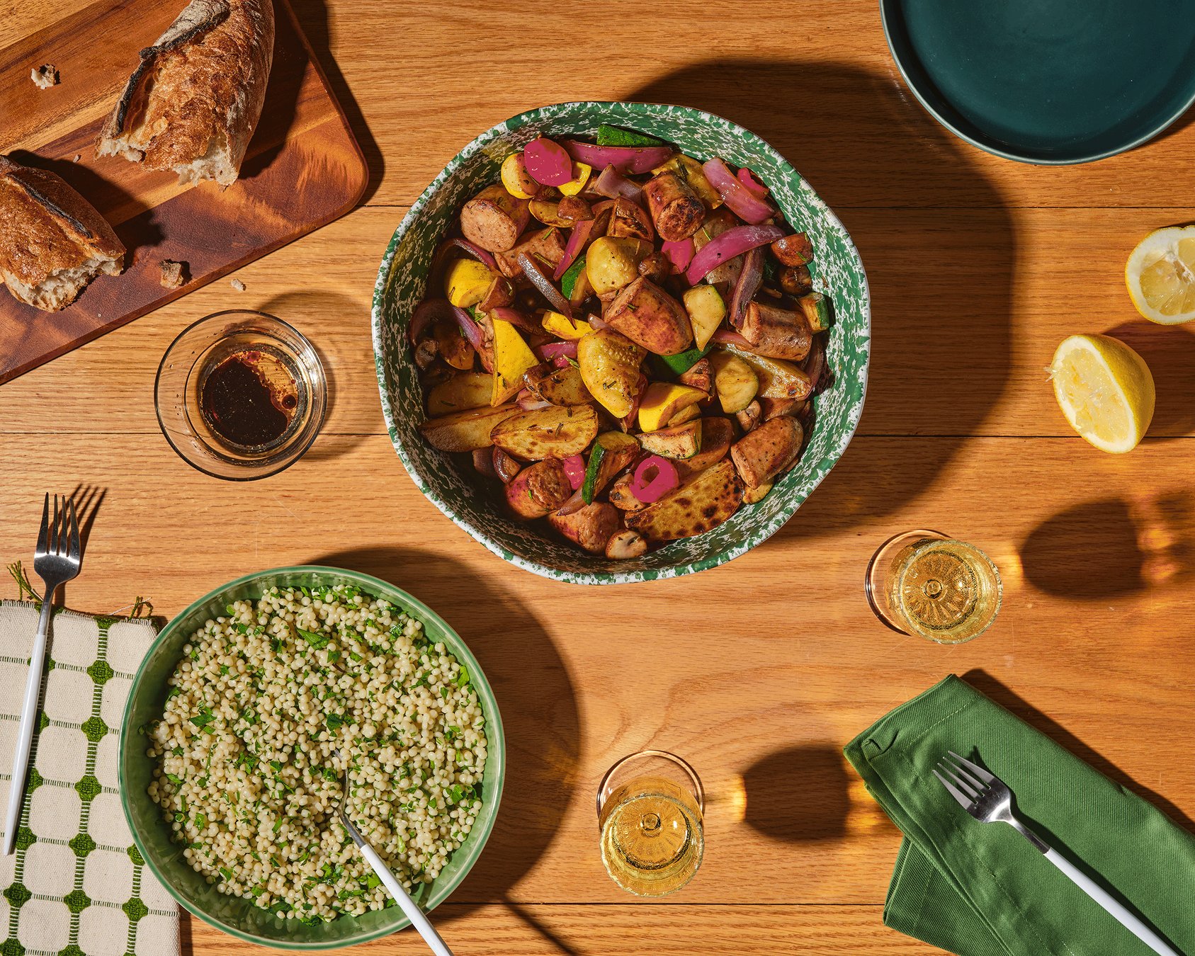 A bowl of roasted Italian Herb chicken sausage with colorful vegetables, rosemary, and olive oil.