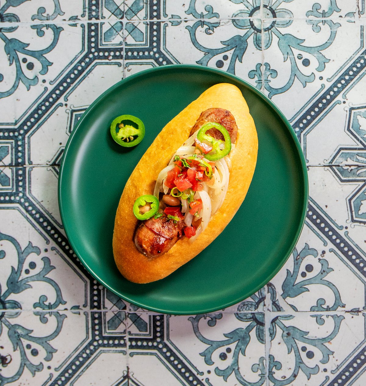 A bacon-wrapped Sonoran dog made with The Sausage Project Melty Cheddar Chicken Sausage.