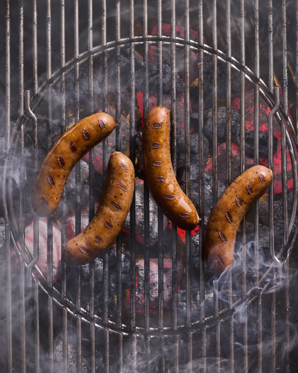 The Sausage Project Classic Roasted Chicken Sausages cooking on a hot grill.