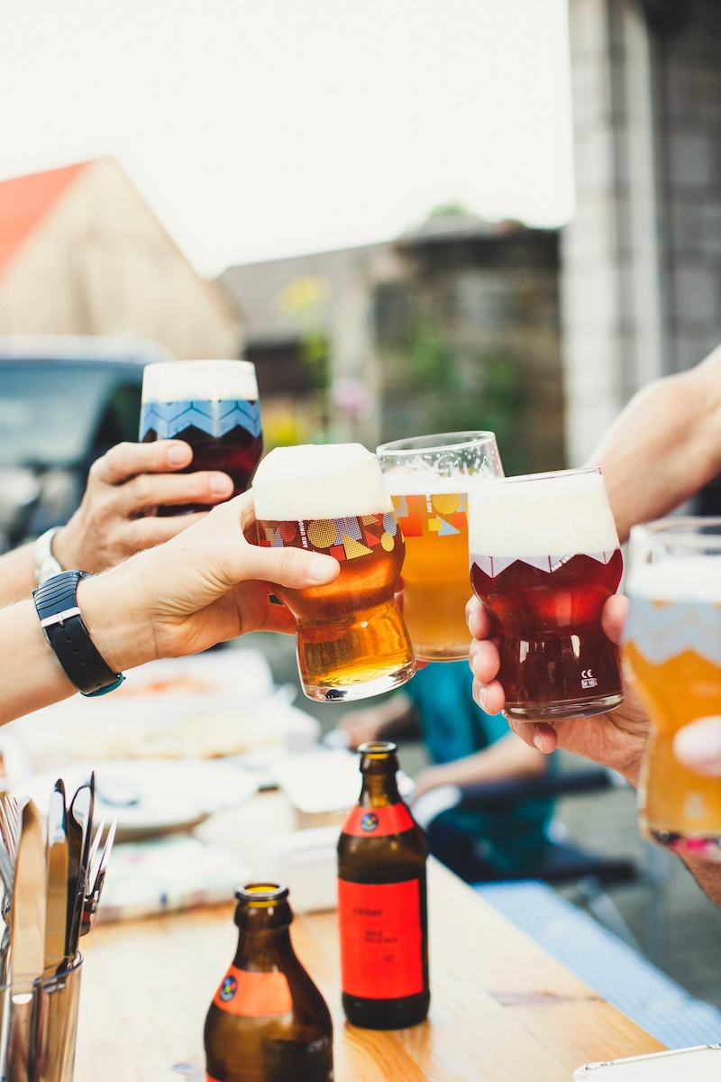 Beer glasses toasting at a BBQ.