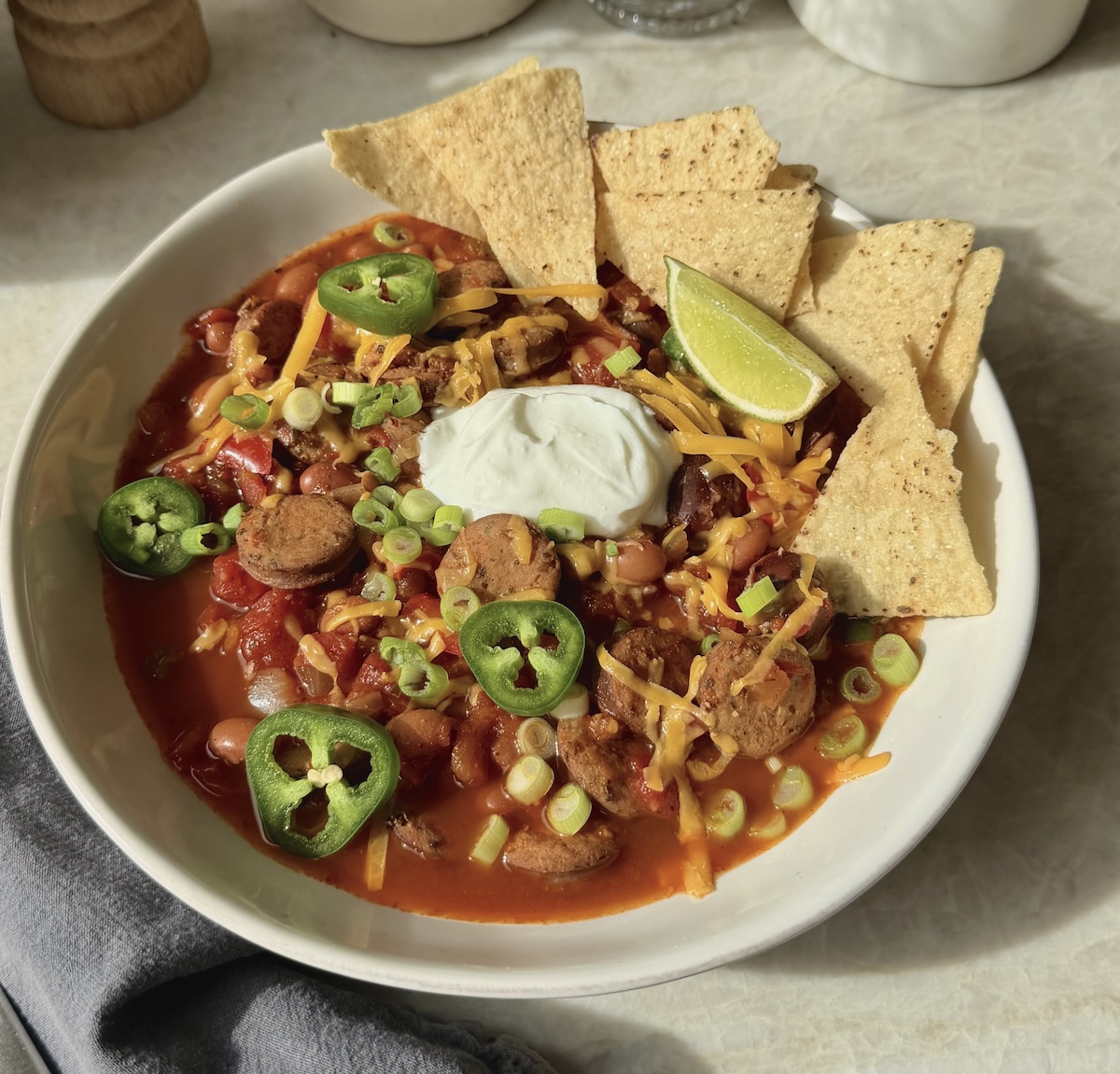 A hearty bowl of chicken sausage chili with toppings.
