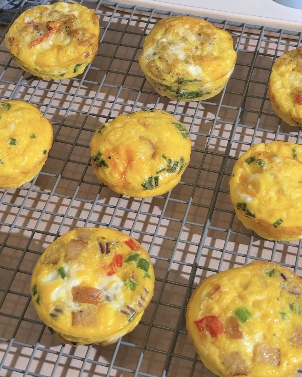 A wire rack filled with three varieties of The Sausage Project egg bites.