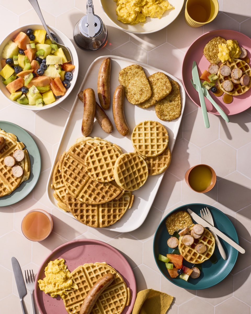 A brunch spread featuring chicken sausage and waffles.