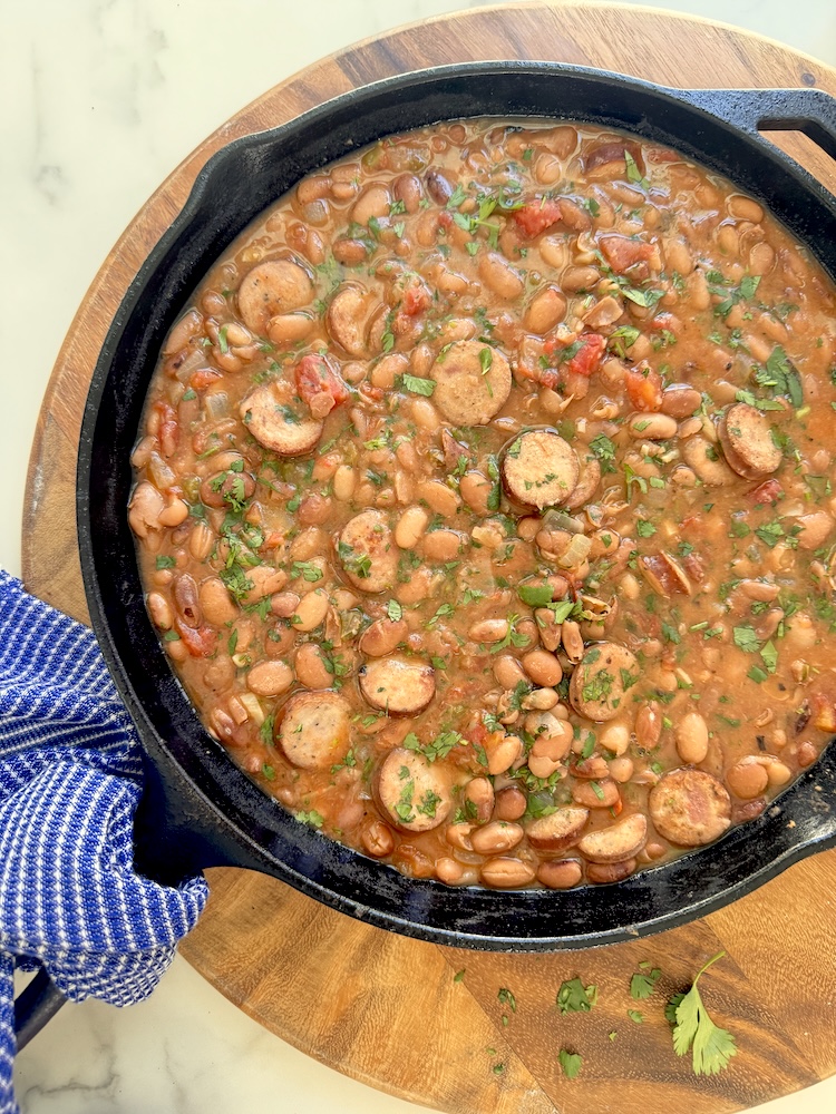 A large skillet of charro beans loaded with Classic Roasted Chicken Sausage.