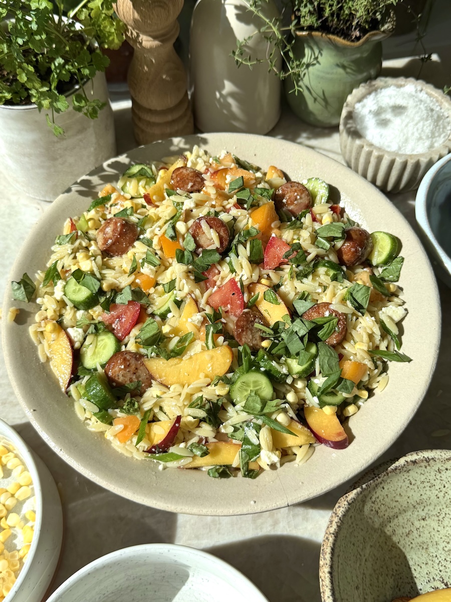 A summer produce-loaded chicken sausage orzo pasta salad.