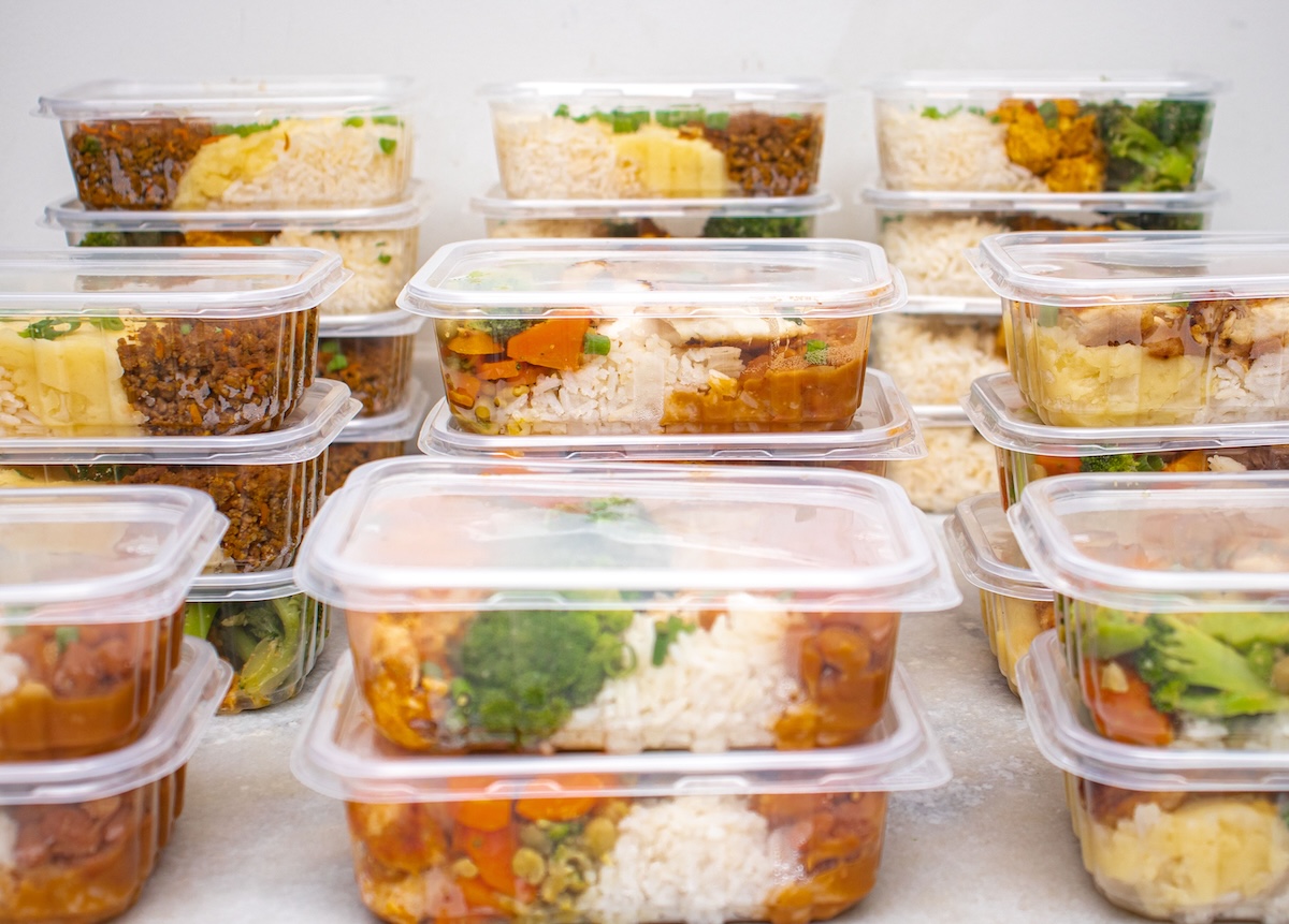 A stack of meal-prep dinners in a refrigerator.
