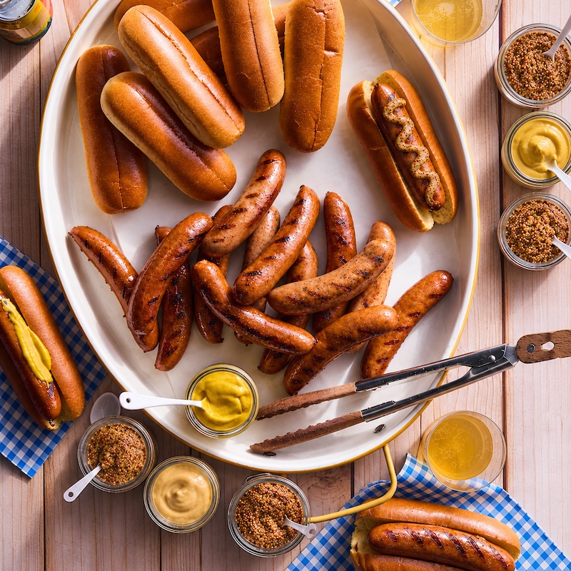 A platter of sausages and mustard.
